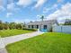 Well-maintained home with a manicured lawn, blue Adirondack chairs, and a welcoming blue front door at 1011 Coldstream Ct, Tarpon Springs, FL 34689