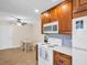 Eat-in kitchen featuring wood cabinets, white appliances, and a dining area for casual meals at 1011 Coldstream Ct, Tarpon Springs, FL 34689
