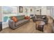 Comfortable living room with wood-look tile floors, neutral-toned sofas, and natural light from the windows at 1011 Coldstream Ct, Tarpon Springs, FL 34689