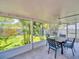 Screened patio features a dining set and views of the landscaped backyard and neighboring fence at 1011 Coldstream Ct, Tarpon Springs, FL 34689