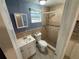 Bathroom featuring a single sink vanity, toilet, tiled shower, and window for natural light at 10414 Rosemount Dr, Tampa, FL 33624