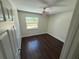 This bedroom features dark wood floor, ceiling fan, and a bright window view at 10414 Rosemount Dr, Tampa, FL 33624