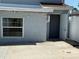A house exterior with an open white door, stucco wall, and a large window showcasing the home's structure at 10414 Rosemount Dr, Tampa, FL 33624