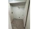Tile floor laundry room with overhead shelf and washer and dryer hookups at 10414 Rosemount Dr, Tampa, FL 33624