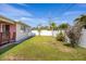 A shot of the backyard, showcasing a well-maintained lawn and privacy fence with mature tropical landscaping at 11225 59Th Ave, Seminole, FL 33772