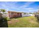 Exterior of the home with a covered porch, spacious grassy backyard and privacy fence at 11225 59Th Ave, Seminole, FL 33772