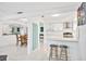 Open-concept kitchen and dining area with modern white cabinetry and stylish bar stool seating at 11225 59Th Ave, Seminole, FL 33772