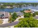 Aerial view of waterfront home with lush landscaping, circle driveway, and neighborhood street at 1124 35Th Ne Ave, St Petersburg, FL 33704