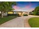 Expansive driveway leads to a charming single-story home with manicured landscaping, and a two-car garage at dusk at 1124 35Th Ne Ave, St Petersburg, FL 33704
