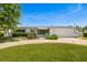 Charming single-story home featuring manicured landscaping, a circular driveway, and an attached two-car garage at 1124 35Th Ne Ave, St Petersburg, FL 33704