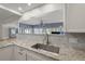 Updated kitchen featuring granite countertops, stainless steel sink and gray backsplash at 1124 35Th Ne Ave, St Petersburg, FL 33704