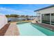 Backyard pool with brick pavers, a white fence and a view of the canal on a sunny day at 1124 35Th Ne Ave, St Petersburg, FL 33704
