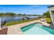 Backyard pool with steps and brick pavers with chairs and a view of the canal on a sunny day at 1124 35Th Ne Ave, St Petersburg, FL 33704