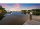 Stunning waterfront view at dusk features a private boat dock in a serene and picturesque setting with vibrant skies at 1124 35Th Ne Ave, St Petersburg, FL 33704