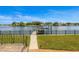 Beautiful waterfront view showcasing a dock with boat lift surrounded by lush landscaping and a secure black fence at 1124 35Th Ne Ave, St Petersburg, FL 33704