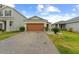 Charming single-story home with a well-manicured lawn and a brick-paved driveway leading to the garage at 11819 Brighton Knoll Loop, Riverview, FL 33579