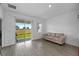 Bright living room features tile floors, neutral sofa, and sliding glass doors to the outdoors at 11819 Brighton Knoll Loop, Riverview, FL 33579