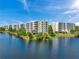 Aerial view of the condo buildings overlooking the lake with pristine landscaping at 1200 Country Club Dr # 5506, Largo, FL 33771
