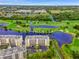 Aerial view featuring manicured golf course and lakefront condo buildings with ample parking at 1200 Country Club Dr # 5506, Largo, FL 33771