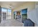View of the tiled balcony featuring a ceiling fan, screens, and glass doors opening to the well-decorated living room at 1200 Country Club Dr # 5506, Largo, FL 33771