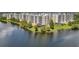 Lakefront condo buildings with palm trees and well-maintained grounds reflected on the water at 1200 Country Club Dr # 5506, Largo, FL 33771