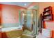 Features a glass shower, garden tub, and modern toilet with matching decor at 12628 White Bluff Rd, Hudson, FL 34669