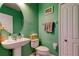Fresh bathroom with pedestal sink, toilet, and green painted walls at 12628 White Bluff Rd, Hudson, FL 34669