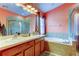 Bright and airy bathroom with double sinks, soaking tub, and separate glass-enclosed shower at 12628 White Bluff Rd, Hudson, FL 34669