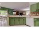 Kitchen featuring green cabinets, white countertops, and open floor plan at 12628 White Bluff Rd, Hudson, FL 34669