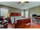 The main bedroom boasts hardwood floors, a ceiling fan, and large windows with a view at 12628 White Bluff Rd, Hudson, FL 34669