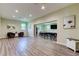 Well-lit community room featuring a large table, chairs, wood laminate flooring, and neutral paint at 12628 White Bluff Rd, Hudson, FL 34669