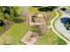 Aerial view of playground with slides, climbing structure, mulch base and paved walkway in community at 12628 White Bluff Rd, Hudson, FL 34669