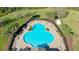 Aerial view of the clover-shaped pool surrounded by palm trees, chairs, and tables, offering a relaxing outdoor amenity at 12628 White Bluff Rd, Hudson, FL 34669