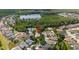 An aerial view of a neighborhood home with a lake view and lush surrounding trees at 12806 Castlemaine Dr, Tampa, FL 33626