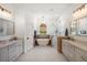 Luxurious bathroom with dual vanities, a soaking tub, and a glass-enclosed shower at 12806 Castlemaine Dr, Tampa, FL 33626
