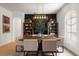 Dining room with a modern chandelier, a dark accent wall, and natural light from an arched window at 12806 Castlemaine Dr, Tampa, FL 33626