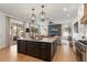 Open-concept kitchen featuring an island with a sleek black cabinet and stainless steel appliances at 12806 Castlemaine Dr, Tampa, FL 33626