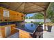 Covered outdoor kitchen includes a built-in grill, bar seating, and ample counter space at 13013 Satin Lily Dr, Riverview, FL 33579