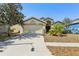 Inviting one-story home featuring a manicured lawn, mature tree, and a convenient two-car garage at 1333 Dragon Head Dr, Valrico, FL 33594