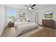 Bright bedroom featuring a ceiling fan, wood floors, and neutral tones at 13981 Lilac Sky Ter, Bradenton, FL 34211