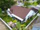 An aerial shot showcasing the home's roof, backyard with patio, screen porch, and well-maintained landscaping at 1424 Ridge Shore Dr, Tarpon Springs, FL 34689