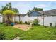 Serene backyard featuring a brick patio, lush greenery, a white fence, and mature trees at 1424 Ridge Shore Dr, Tarpon Springs, FL 34689