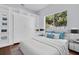 Bright bedroom featuring large window, built-in shelving, murphy bed, hardwood floors, and soft blue walls at 1424 Ridge Shore Dr, Tarpon Springs, FL 34689