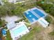 Aerial view featuring a swimming pool, tennis courts, basketball courts, and a parking lot at 1424 Ridge Shore Dr, Tarpon Springs, FL 34689