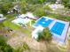 Aerial view of the community pool, basketball court, tennis court and playground area at 1424 Ridge Shore Dr, Tarpon Springs, FL 34689