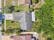 Aerial view of a single Gathering home with a manicured lawn, mature trees, and a paved driveway at 15014 Winterwind Dr, Tampa, FL 33624