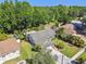 Aerial view of a cozy home surrounded by mature trees, green lawns, and neighboring houses at 15014 Winterwind Dr, Tampa, FL 33624