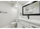 Bathroom showcasing a modern vanity with marble countertop, black hardware, and a sleek mirror at 15014 Winterwind Dr, Tampa, FL 33624
