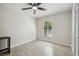 Cozy bedroom with tile floors, natural light, ceiling fan, and large window with lush backyard views at 15014 Winterwind Dr, Tampa, FL 33624
