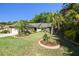 Beautifully landscaped front yard with lush greenery and a well-maintained lawn surrounding the single Gathering home at 15014 Winterwind Dr, Tampa, FL 33624